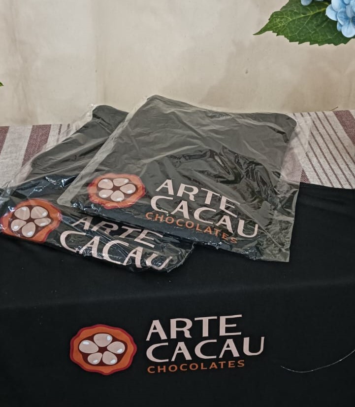 Camiseta oficial Arte Cacau Chocolates incluída no pedido da campanha