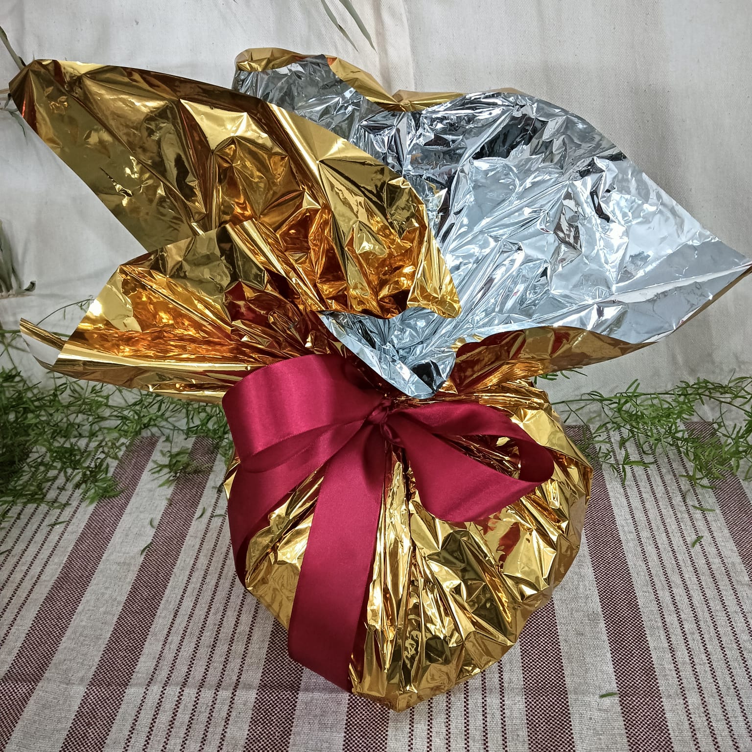 Coração de chocolate de 1kg embalado em papel dourado e prateado com laço bordô — ação promocional Arte Cacau